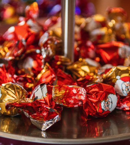 Close-up of colorful wrapped chocolates on a tray, perfect for Christmas celebrations.